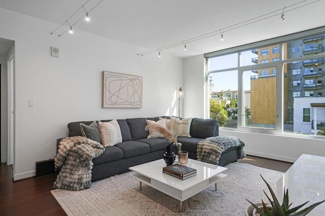 living room with rail lighting and dark wood-type flooring