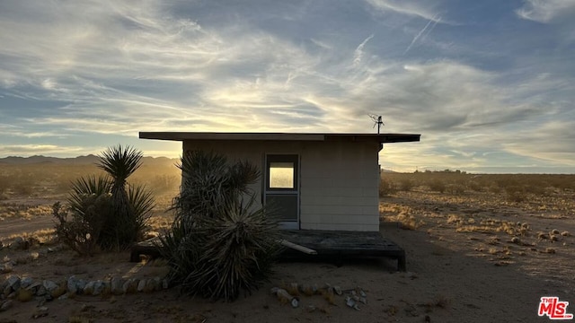 property exterior at dusk featuring an outbuilding