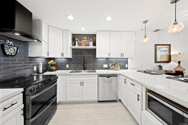 kitchen with sink, wall chimney exhaust hood, stainless steel appliances, pendant lighting, and white cabinets