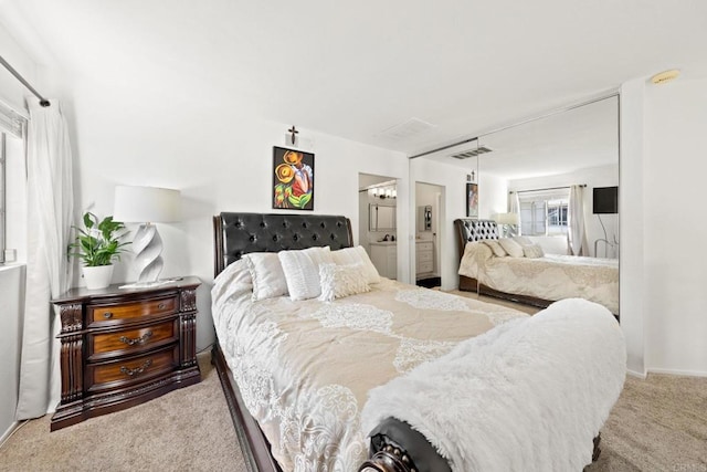 bedroom featuring light carpet and connected bathroom