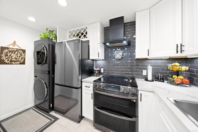 kitchen with stainless steel appliances, white cabinetry, and wall chimney range hood