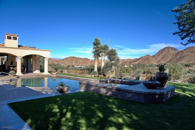 view of pool with a mountain view, a yard, and a patio