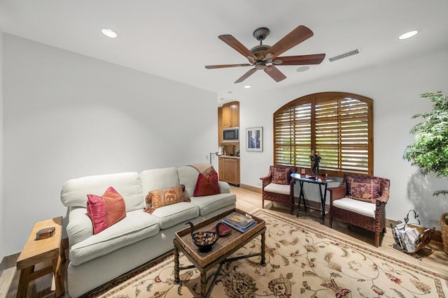 living room with ceiling fan and light hardwood / wood-style floors