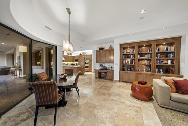 dining area featuring a raised ceiling and built in features