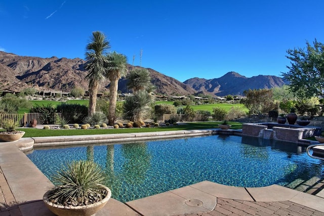 view of swimming pool with a mountain view and an in ground hot tub