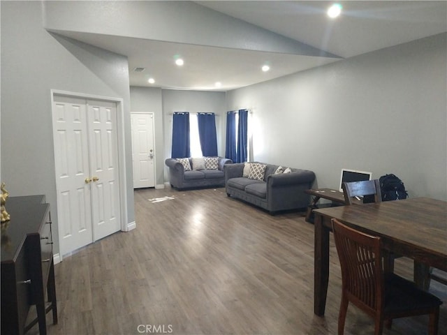 living room featuring lofted ceiling and dark hardwood / wood-style floors