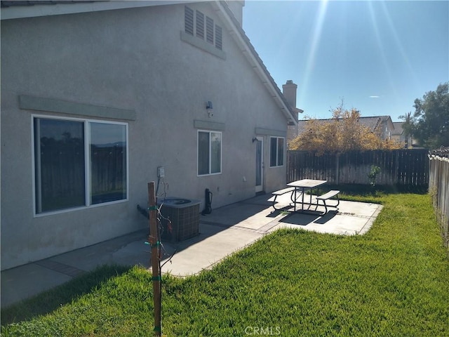 rear view of house with a yard, central AC unit, and a patio area