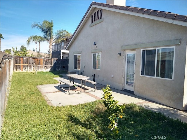 back of property featuring a yard and a patio