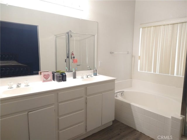 bathroom with vanity, wood-type flooring, and plus walk in shower