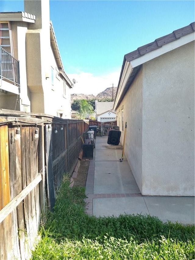 view of property exterior with a mountain view and a patio area