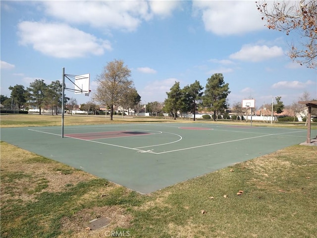 view of basketball court with a yard