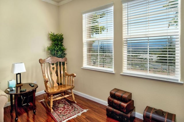 living area with plenty of natural light, dark hardwood / wood-style flooring, and ornamental molding