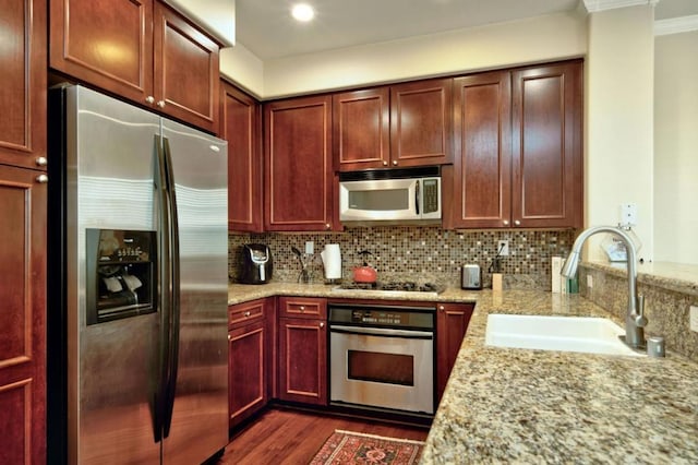 kitchen with light stone countertops, sink, stainless steel appliances, dark hardwood / wood-style flooring, and ornamental molding