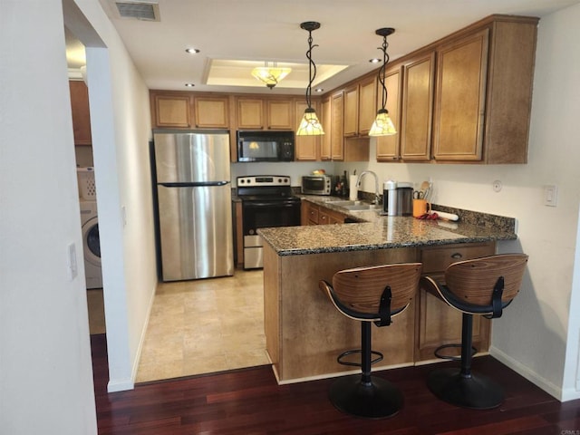 kitchen featuring sink, stainless steel fridge, hanging light fixtures, electric range, and kitchen peninsula