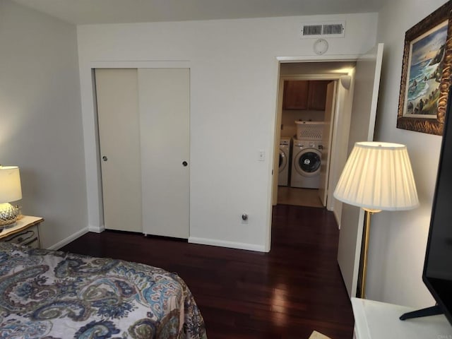 bedroom with dark hardwood / wood-style flooring, washer and clothes dryer, and a closet