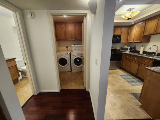 clothes washing area featuring separate washer and dryer, sink, and hardwood / wood-style floors