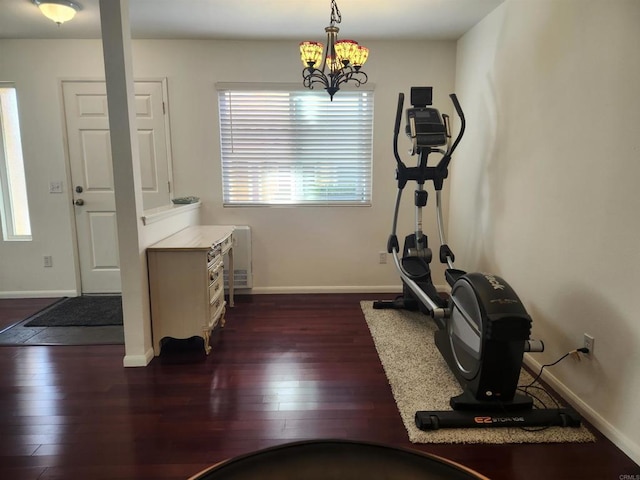 workout area with dark hardwood / wood-style floors and a chandelier