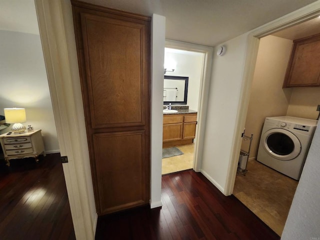 clothes washing area with dark wood-type flooring, cabinets, washer / clothes dryer, and sink