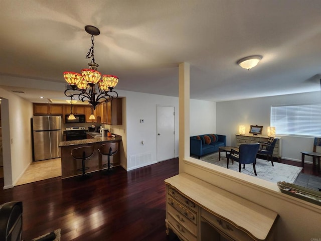 living room with an inviting chandelier and dark hardwood / wood-style flooring