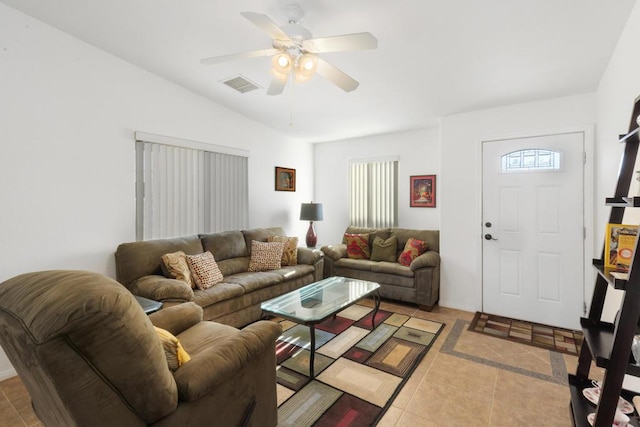 living room with ceiling fan, plenty of natural light, light tile patterned floors, and lofted ceiling