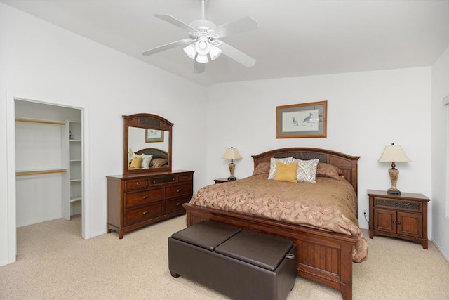 bedroom featuring ceiling fan, a spacious closet, light carpet, and vaulted ceiling