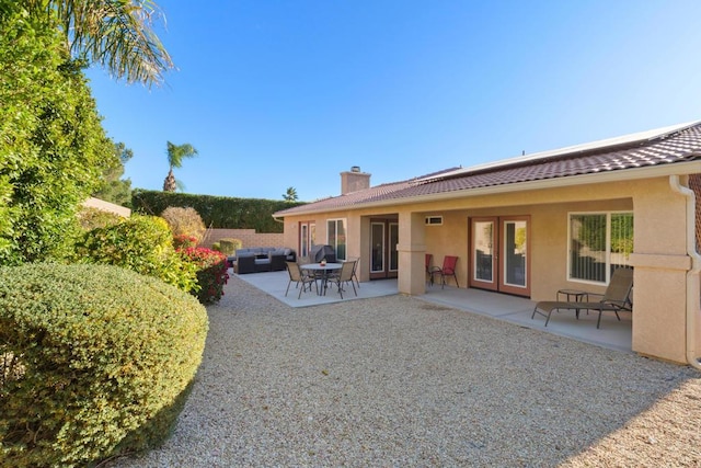 back of house featuring an outdoor living space and a patio