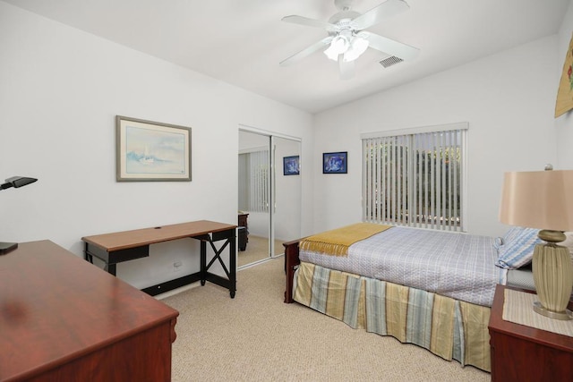 bedroom featuring ceiling fan, a closet, light carpet, and vaulted ceiling