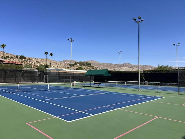 view of sport court with a mountain view and basketball hoop