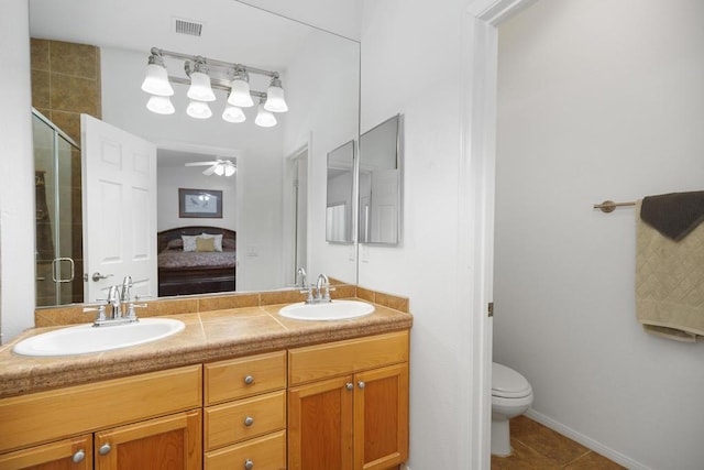 bathroom with ceiling fan, tile patterned flooring, an enclosed shower, toilet, and vanity