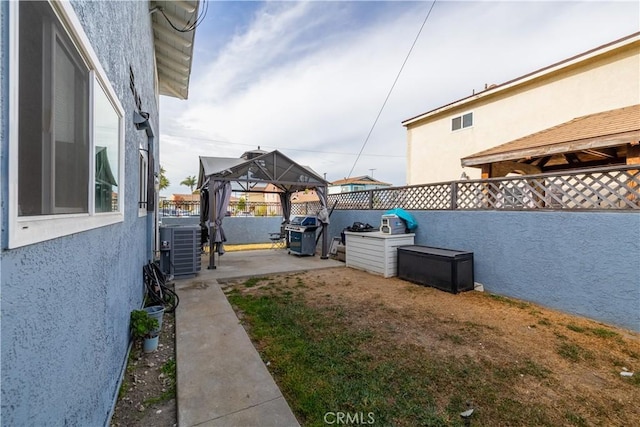 view of yard featuring a gazebo and central AC