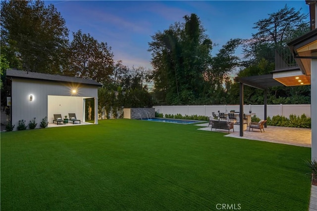 yard at dusk featuring a fenced in pool and a patio area