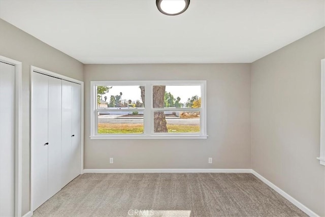 unfurnished bedroom featuring light carpet