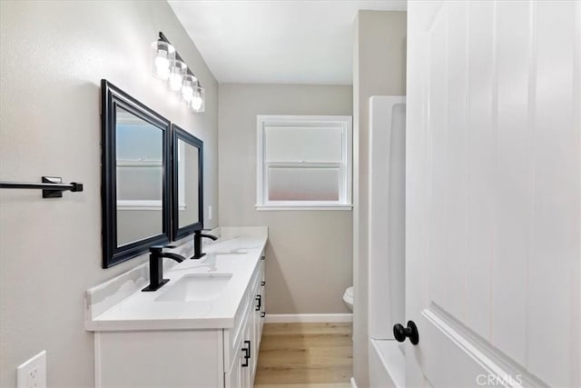 bathroom with hardwood / wood-style floors, vanity, and toilet