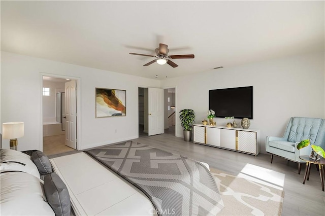 bedroom featuring ceiling fan, connected bathroom, and light hardwood / wood-style flooring