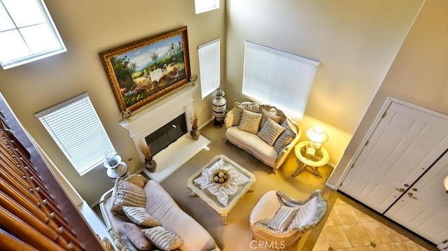 living room with a healthy amount of sunlight, light tile patterned floors, and a high ceiling