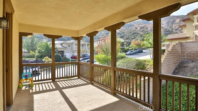 wooden deck with a mountain view and covered porch