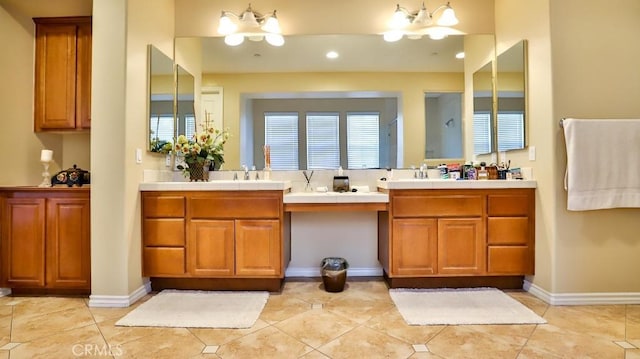 bathroom featuring tile patterned flooring, a notable chandelier, and vanity