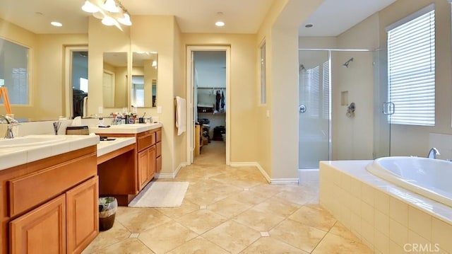 bathroom featuring plus walk in shower, vanity, and tile patterned floors