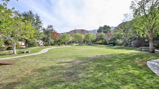 surrounding community with a mountain view and a yard