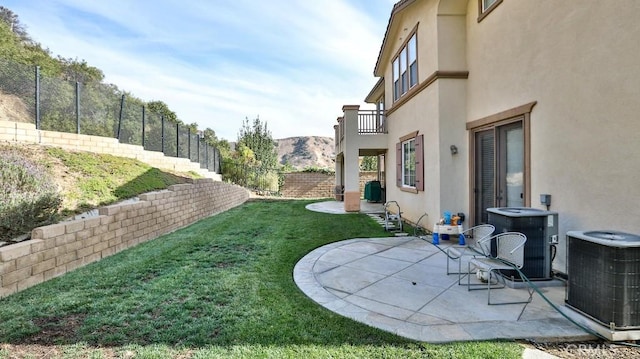 view of yard with central AC unit, a mountain view, a patio area, and a balcony