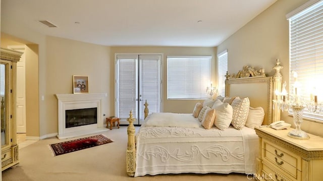 bedroom with light colored carpet and multiple windows