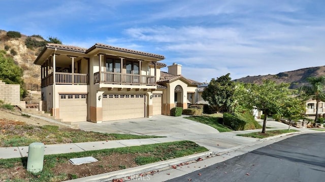 mediterranean / spanish house featuring a mountain view, a balcony, and a garage