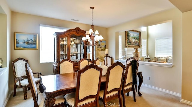 carpeted dining space featuring an inviting chandelier