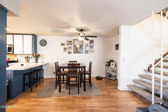 dining area with ceiling fan and light hardwood / wood-style flooring