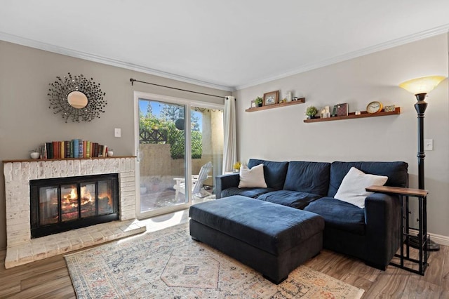 living room with wood-type flooring, crown molding, and a brick fireplace