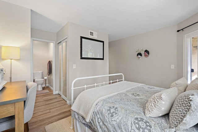 bedroom featuring ensuite bath, a closet, and light hardwood / wood-style floors