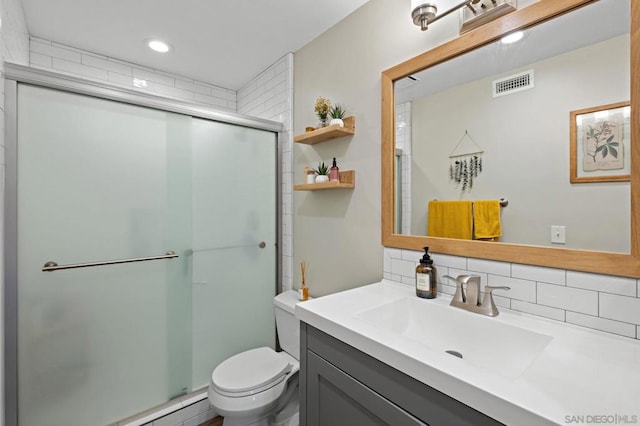 bathroom featuring decorative backsplash, vanity, baseboard heating, a shower with door, and toilet