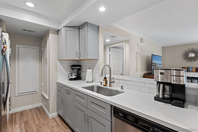 kitchen featuring gray cabinetry, sink, decorative backsplash, ornamental molding, and light hardwood / wood-style floors