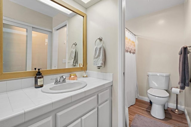 bathroom featuring toilet, vanity, and hardwood / wood-style flooring