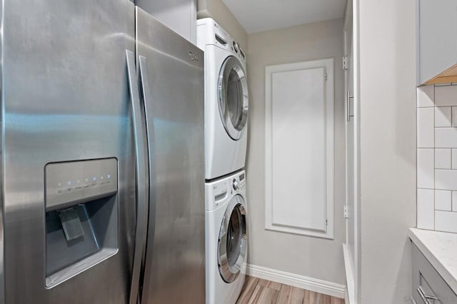 laundry area featuring light hardwood / wood-style floors and stacked washer and clothes dryer